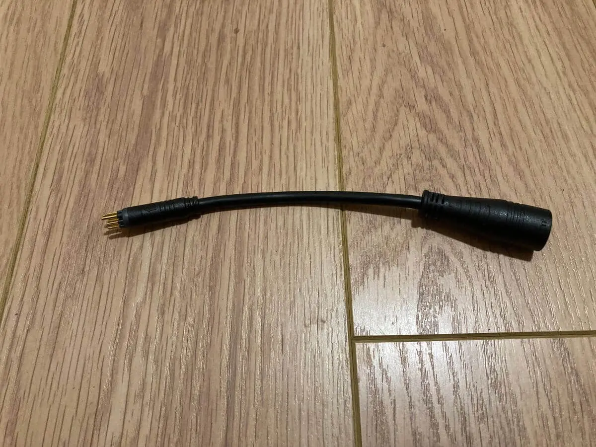 Small cable connector on brown flooring
