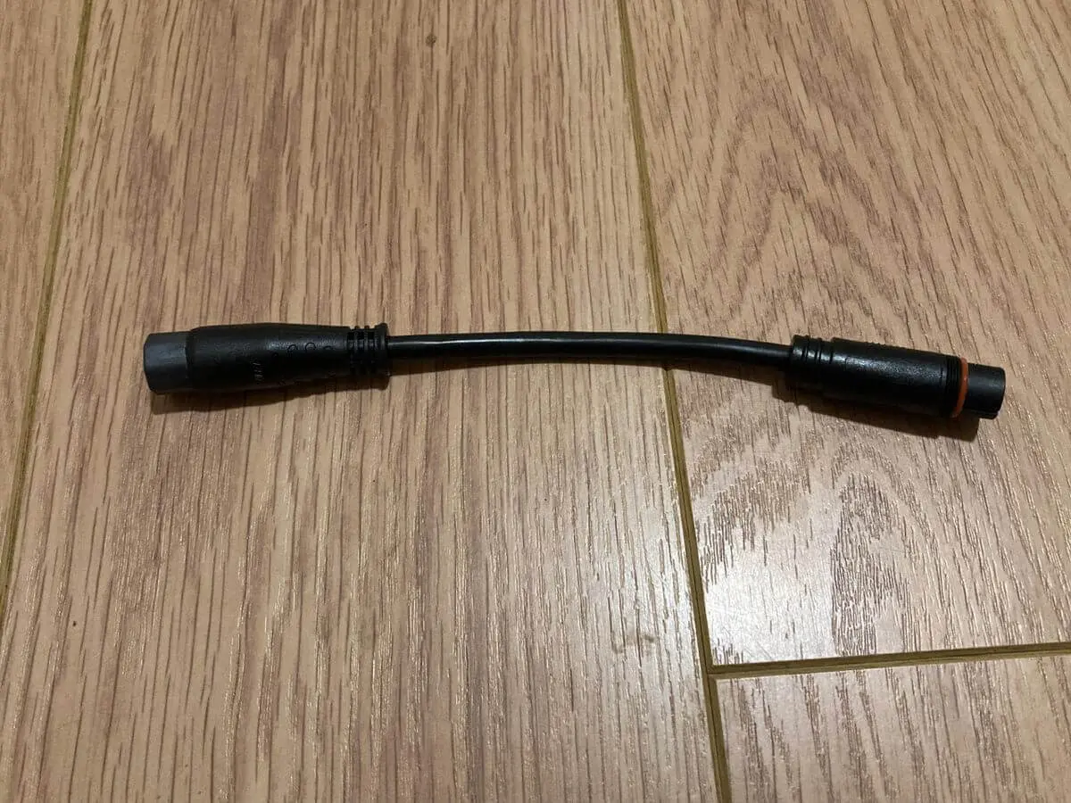 Short black connector cable on floor