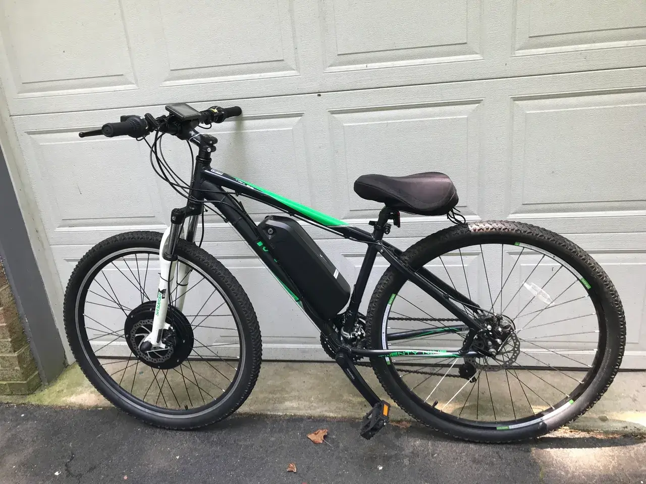 Black and green electric bike by garage