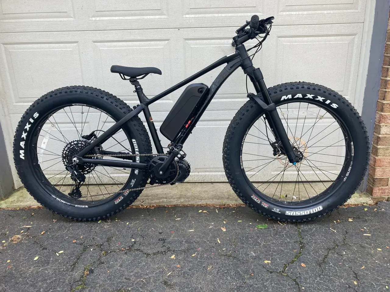 Modern e-bike parked near white garage