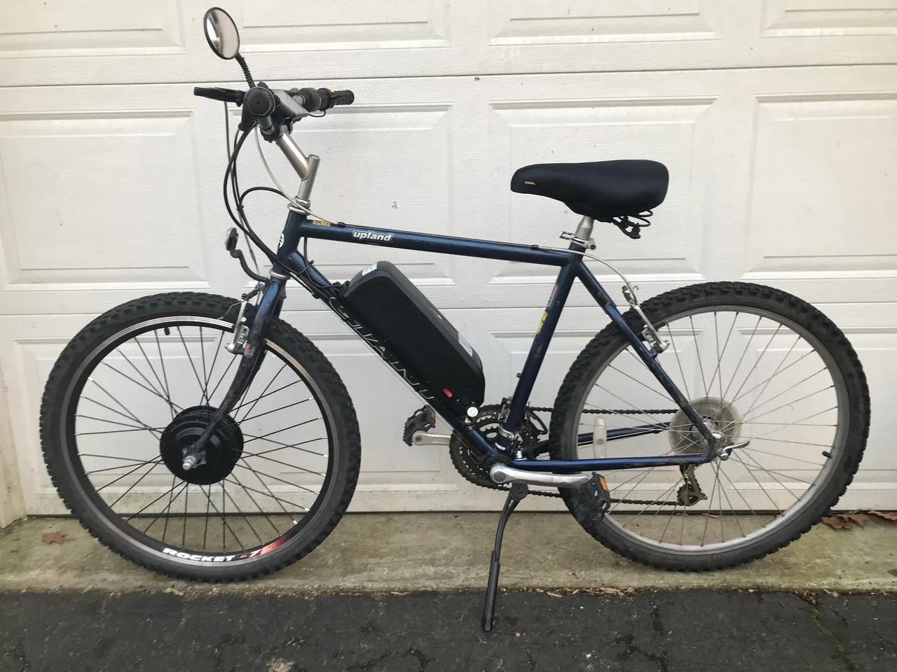 Electric bike parked against garage door