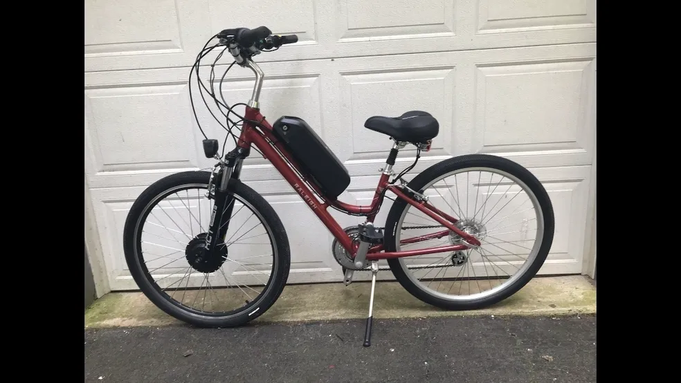 Bicycle parked in front of white garage.